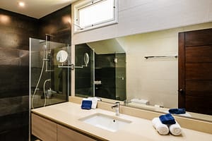 Elegant bathroom at Casa Kenya featuring modern fixtures, a spa-like ambiance, and high-end finishes in Hacienda Pinilla, Costa Rica.