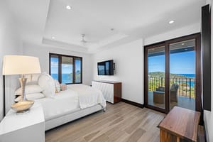 Elegant ocean-view bedroom with floor-to-ceiling windows, a plush bed, and direct access to a private veranda at 360 Splendor del Pacifico Flamingo.