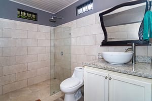 Modern and elegantly designed bathrooms with private en-suite features, luxury finishes, and stunning rainforest views in a mountain retreat near Arenal Volcano, Costa Rica.