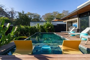 Turquoise swimming pool surrounded by tropical gardens at Villa Aquarena near Tamarindo Beach