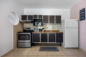 Fully equipped kitchen in the 2-bedroom guest unit with modern appliances and wood cabinetry at Casa Veranera