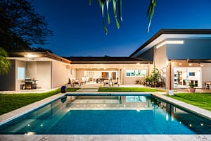 Stunning nighttime view of Casa Kenya, featuring a beautifully illuminated pool and modern tropical architecture in Hacienda Pinilla, Costa Rica.