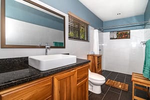Modern and elegantly designed bathrooms with private en-suite features, luxury finishes, and stunning rainforest views in a mountain retreat near Arenal Volcano, Costa Rica.