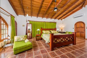 Spacious bedroom with teak wood accents and ocean view at Casa Margarita, Playa Flamingo