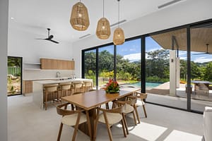 Elegant dining area in Casa Aguasalada, featuring a spacious wooden table, stylish seating, and an open-concept design with views of the tropical surroundings.
