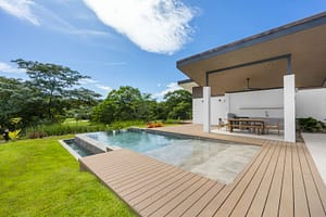 Infinity pool at Casa Aguasalada overlooking the Robert Trent Jones II Golf Course, surrounded by lush tropical landscaping.