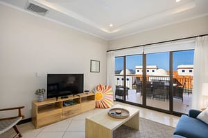 Modern living room with blue sofa, accent chairs, and ocean view at Flamingo Towers 11, Playa Flamingo.