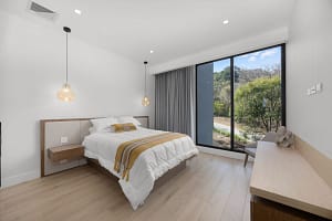 Elegant guest bedroom at Solaris Acacia 1A in Reserva Conchal, featuring modern décor, plush bedding, and large windows with lush tropical views.