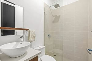 Luxurious bathroom in Villa Oceana with dual vanities, a walk-in shower, and a soaking tub offering elegant tropical design.