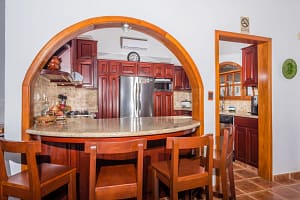 Spacious kitchen with teak wood accents and modern appliances at Casa Margarita, Playa Flamingo
