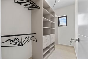Elegant walk-in closet at Casa Camari featuring custom-built shelving, ample storage, and luxurious finishes.