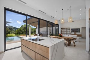 Modern open-concept kitchen in Casa Aguasalada, featuring sleek countertops, high-end appliances, and elegant teak cabinetry with a spacious island.