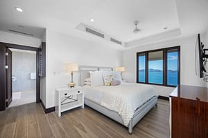 Elegant ocean-view bedroom with floor-to-ceiling windows, a plush bed, and direct access to a private veranda at 360 Splendor del Pacifico Flamingo.