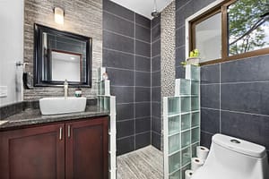 Elegant en-suite bathroom in the main house with modern fixtures, a spacious vanity, and natural light.