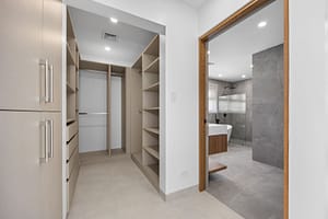 Spacious walk-in closet in Casa Aguasalada, featuring custom teak shelving, ample storage, and elegant lighting.