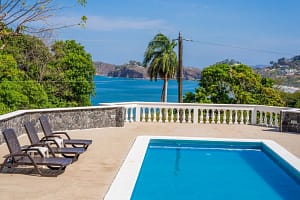 Expansive private pool surrounded by tropical gardens at Casa Margarita, Playa Flamingo