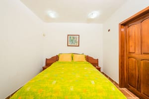 Spacious bedroom with teak wood accents and ocean view at Casa Margarita, Playa Flamingo