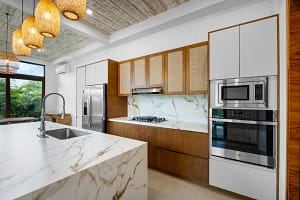 Modern kitchen with high-end appliances and island seating at Tamarindo Park #51 in Playa Tamarindo.