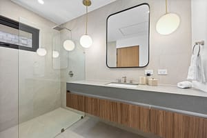 Modern bathroom in Casa Aguasalada, featuring a sleek vanity, walk-in shower, and elegant teak accents.