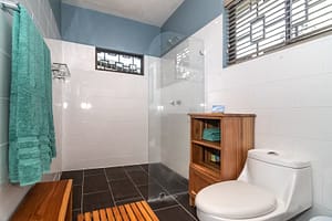 Modern and elegantly designed bathrooms with private en-suite features, luxury finishes, and stunning rainforest views in a mountain retreat near Arenal Volcano, Costa Rica.