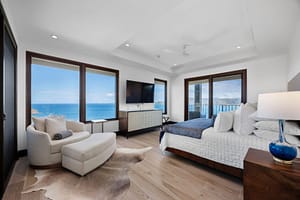 Elegant ocean-view bedroom with floor-to-ceiling windows, a plush bed, and direct access to a private veranda at 360 Splendor del Pacifico Flamingo.