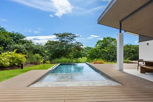 Infinity pool at Casa Aguasalada overlooking the Robert Trent Jones II Golf Course, surrounded by lush tropical landscaping.
