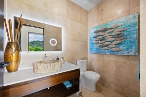 Luxurious ensuite bathroom with custom stone sinks and oversized rain shower overlooking the ocean at Casa Seahorse in Mar Vista, Playa Flamingo.