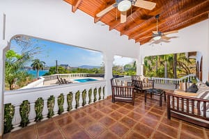 Spacious wraparound terrace with tropical garden and pool views at Casa Margarita, Playa Flamingo