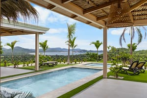 Luxurious infinity pool with jacuzzi overlooking the ocean at Casa Camari, Playa Potrero. Surrounded by tropical landscaping and elegant outdoor lounging spaces.