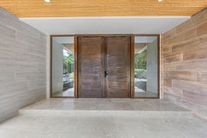 Elegant grand wooden door at Casa Manta Ray, offering a warm and luxurious entrance.