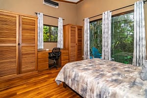 Spacious and elegantly designed bedrooms with panoramic views, queen-size beds, and modern furnishings in a luxury mountain retreat near Arenal Volcano, Costa Rica.
