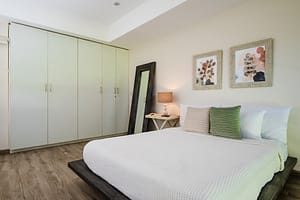 Elegant and spacious bedroom at Casa Kenya, featuring luxurious bedding, modern decor, and serene tropical views in Hacienda Pinilla, Costa Rica.