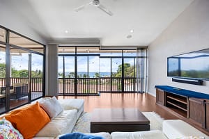 Spacious living room with high ceilings, natural light, and tropical garden views at Casa Veranera
