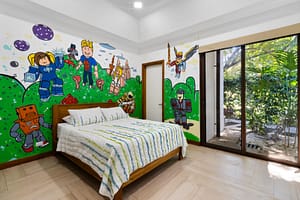 Spacious and stylish bedroom at Casa Artistica, featuring custom-painted walls, elegant furnishings, and an ensuite bathroom for ultimate comfort.