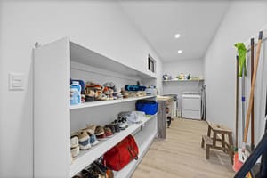 Spacious and well-organized shoe storage and laundry room at Casa Camari, featuring custom shelving, ample storage, and high-end appliances.