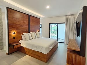 Luxurious master bedroom with king bed, high ceilings, and pool views at Llama del Bosque 27 in Reserva Conchal