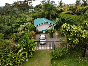 Aerial view of a luxury mountain retreat near Arenal Volcano, featuring two elegant homes, lush tropical gardens, and breathtaking rainforest surroundings.