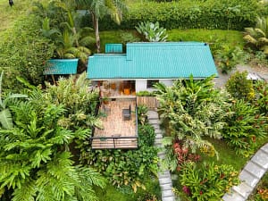 Aerial view of a luxury mountain retreat near Arenal Volcano, featuring two elegant homes, lush tropical gardens, and breathtaking rainforest surroundings.
