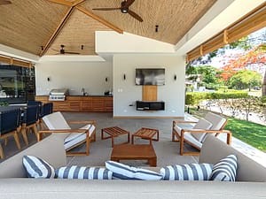 Covered terrace with BBQ, lounge seating, and outdoor dining area at Llama del Bosque 27, Reserva Conchal