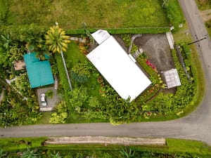 Aerial view of a luxury mountain retreat near Arenal Volcano, featuring two elegant homes, lush tropical gardens, and breathtaking rainforest surroundings.