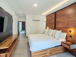 Luxurious master bedroom with king bed, high ceilings, and pool views at Llama del Bosque 27 in Reserva Conchal
