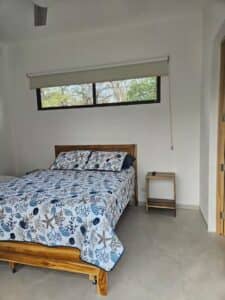 Spacious and elegantly designed bedroom in Villa Praga, Playa Grande, featuring a king-size bed, modern décor, and natural lighting.