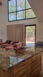 Spacious and stylish living room in Villa Praga, Playa Grande, featuring modern furnishings, natural lighting, and seamless indoor-outdoor flow.