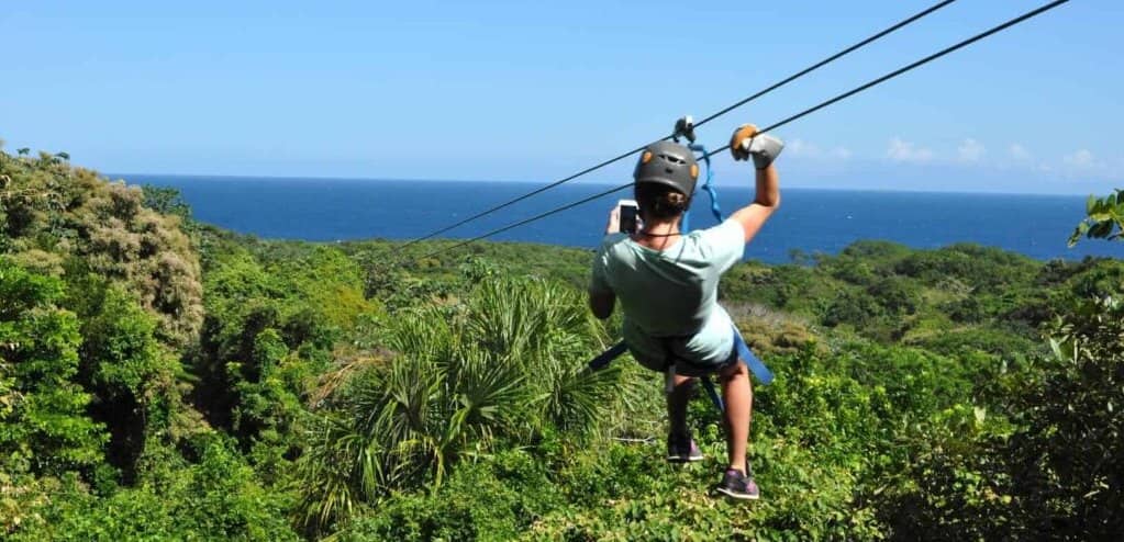 A person ziplining over the rainforest in Roatan, Honduras